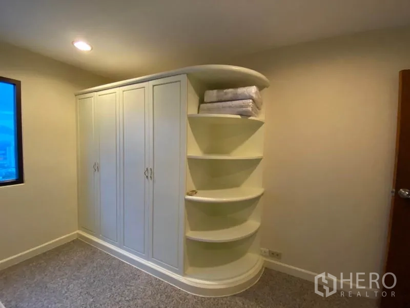 คอนโด ให้เช่าในWatthana, Bangkok - ตู้เสื้อผ้าบิวท์อินพร้อมชั้นเปิดโค้งมนภายในห้องนอน