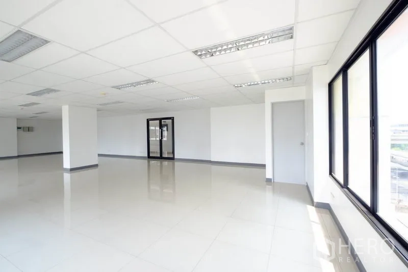 Office Space for rent in Suan Luang, Bangkok - Open office space with multiple windows, glass entry door and polished flooring.