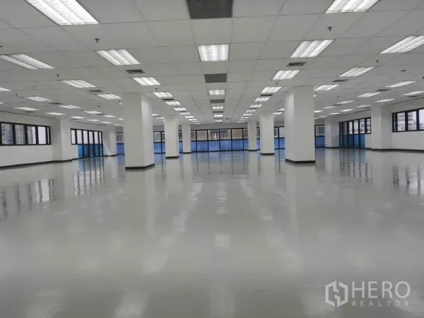 办公空间 出租在Phaya Thai, Bangkok - 宽敞开放式办公楼层，亮面地坪、栅格吊顶灯、白色立柱与环窗采光。