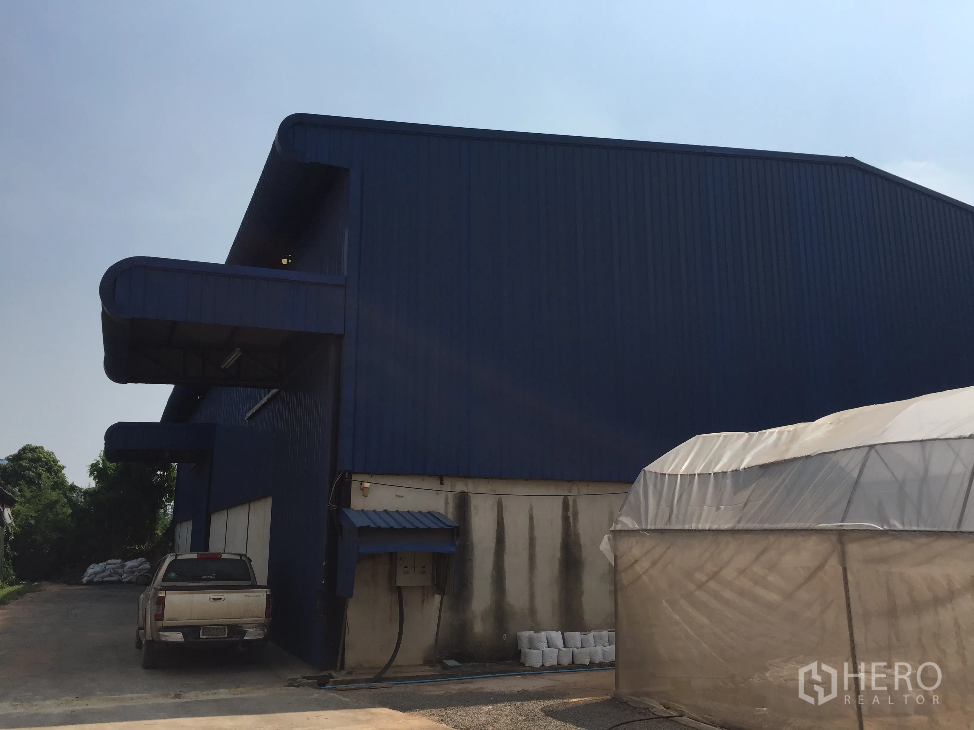 Warehouse for rent in Lat Krabang, Bangkok - Blue steel-clad warehouse exterior with covered loading bays and driveway in Lat Krabang.