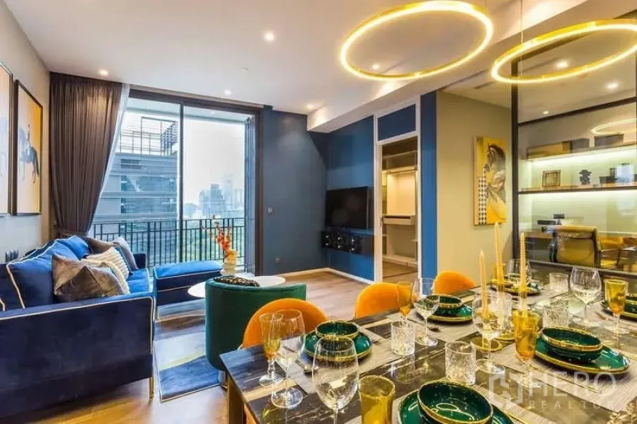 Condominium for rent in Pathum Wan, Bangkok - Stylish dining setup with gold ring lights beside the living room and balcony.