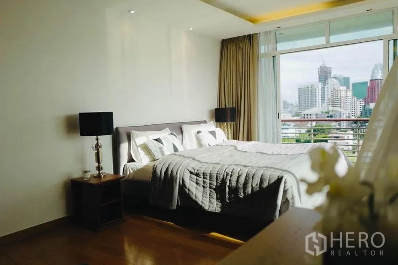 คอนโด ให้เช่าหรือขายในPhaya Thai, Bangkok - ห้องนอนมาสเตอร์กว้าง หน้าต่างบานใหญ่ ผ้าม่านโทนอุ่น และวิวเมืองจากระเบียง