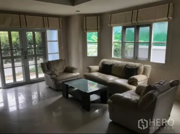 บ้าน ขาย - ห้องนั่งเล่นสว่าง โซฟาหนัง โต๊ะกระจก และหน้าต่างบานใหญ่