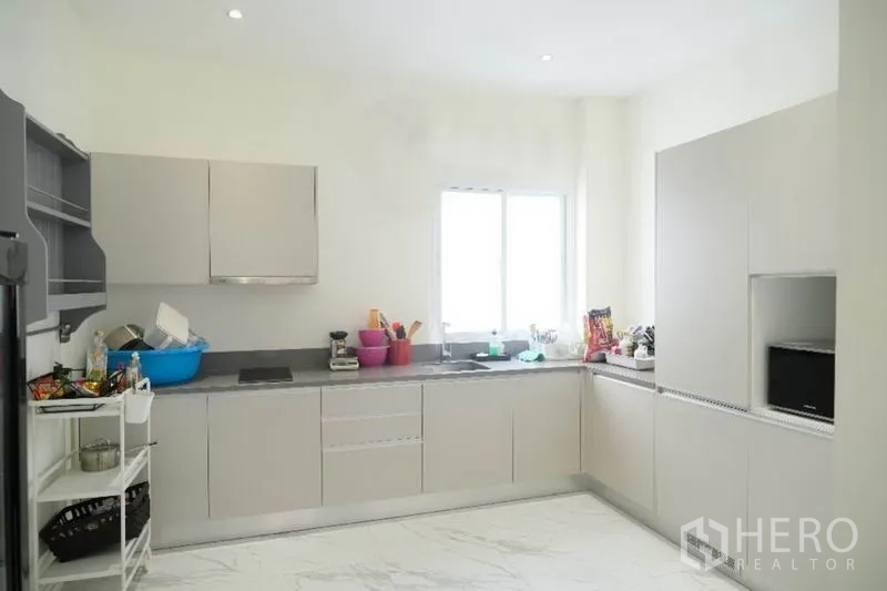 Home Office for rent or sale in Prawet, Bangkok - L-shaped modern kitchen with light cabinetry, stone countertops and window for natural light.