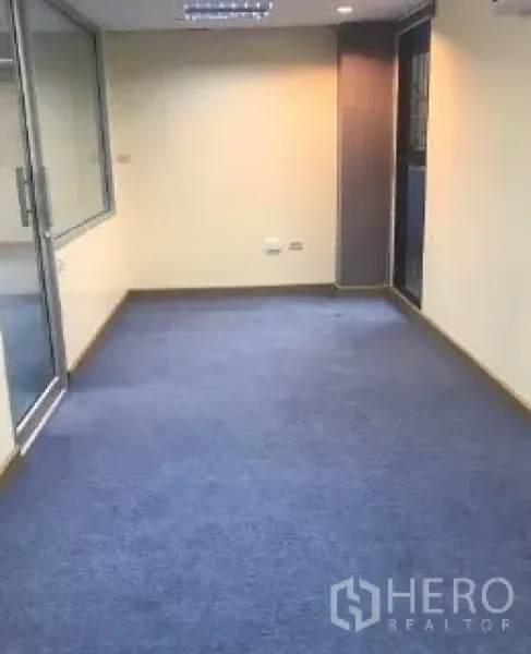 办公空间 出租在Bang Rak, Bangkok - 蓝色地毯的办公区，带玻璃隔断门与吊顶灯。