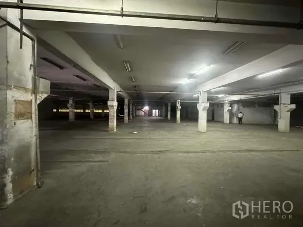 Factory for rent in Khlong Luang, Pathum Thani - Vast columned industrial floor with fluorescent lighting and a concrete surface