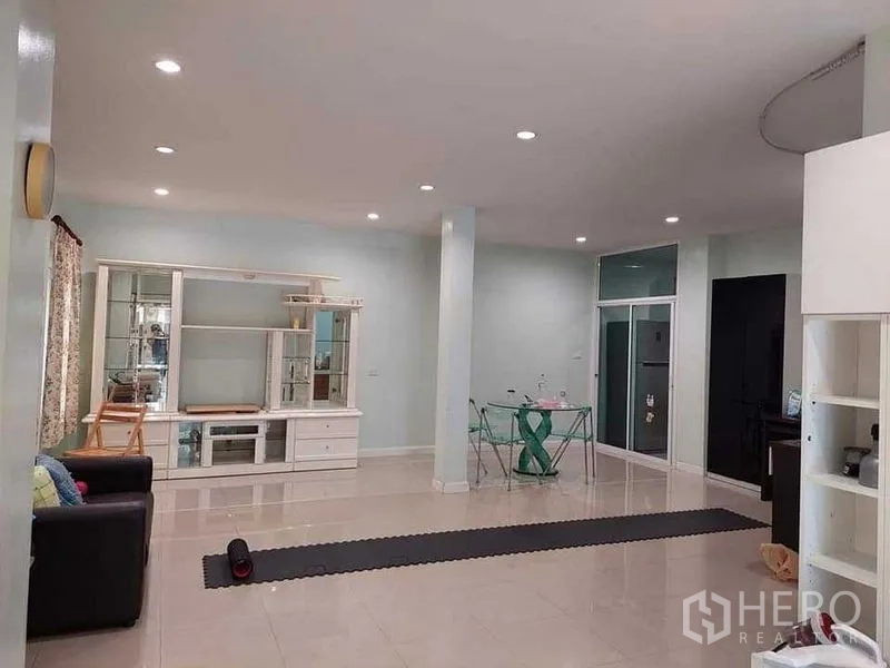 Detached House for sale in Bueng Kum, Bangkok - Bright open-plan living room with white built-in cabinet, tiled floor and recessed lights.