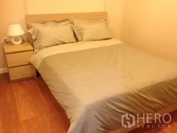 คอนโด ให้เช่าหรือขายในWatthana, Bangkok - ห้องนอนอบอุ่น เตียงคู่ พื้นไม้ พร้อมโต๊ะข้างเตียงและโคมไฟ