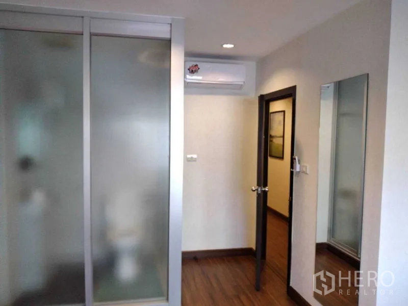 อาคารพาณิชย์ ให้เช่าในWatthana, Bangkok - มุมห้องกั้นกระจกฝ้า มีกระจกเงาติดผนัง และเครื่องปรับอากาศเหนือประตู.