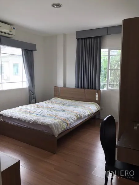 Detached House for rent in Khlong Sam Wa, Bangkok - Cozy bedroom with double bed, study desk and large windows.