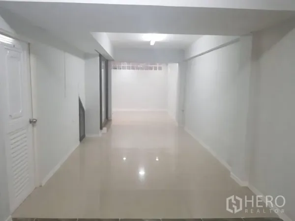 店屋 出租或出售在Lat Phrao, Bangkok - 一层明亮开放式空间，白墙与亮面瓷砖地面。