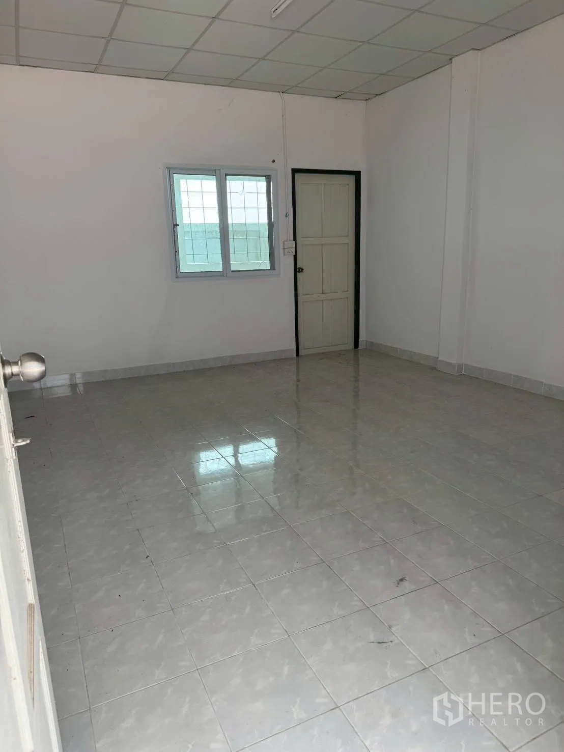 Warehouse for rent in Phutthamonthon, Nakhon Pathom - Simple tiled room with window and door, suitable for staff or storage use.