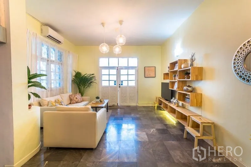 带办公室的家 出租在Suan Luang, Bangkok - 客厅朝双开入户门，电视墙与层架清晰可见。