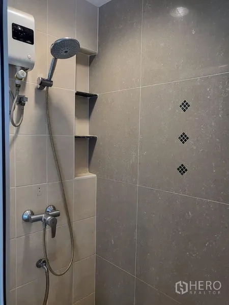 Townhouse for rent in Wang Thonglang, Bangkok - Close-up of tiled shower with water heater and handheld rain shower.
