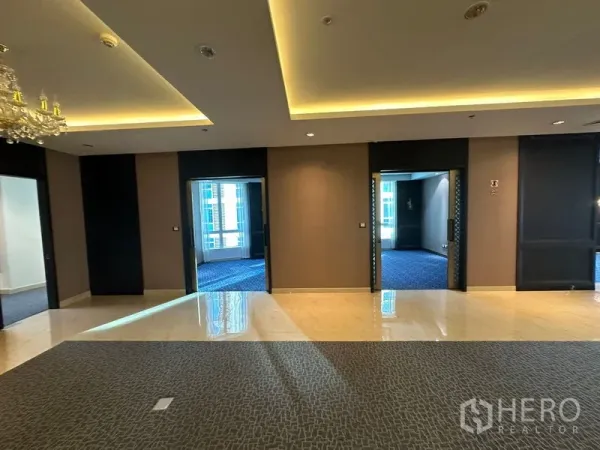 Office Space for rent - Corridor linking multiple rooms with tray ceilings, cove lighting and mixed flooring.