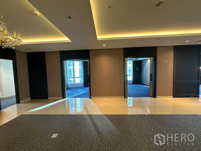 Office Space for rent - Corridor linking multiple rooms with tray ceilings, cove lighting and mixed flooring.