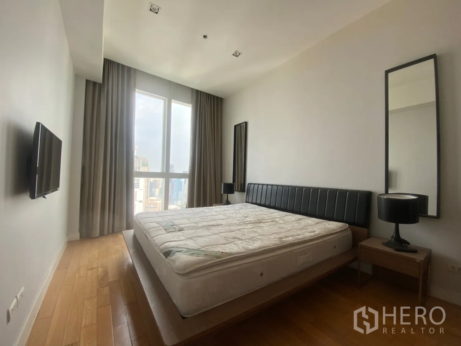 คอนโด ให้เช่าหรือขายในKhlong Toei, Bangkok - ห้องนอนใหญ่มีหน้าต่างบานสูง วิวเมือง เตียงแพลตฟอร์ม โต๊ะข้างเตียง และทีวีติดผนัง