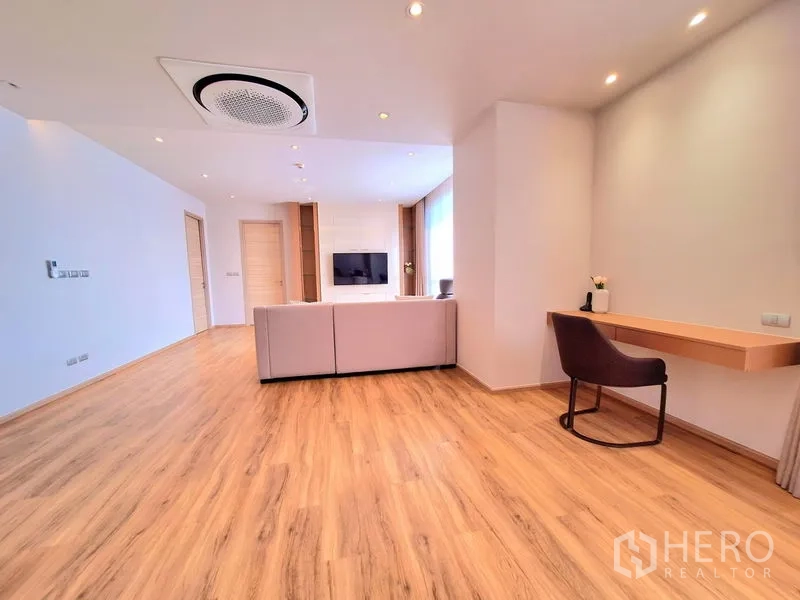 อพาร์ทเมนท์ ให้เช่าในBang Na, Bangkok - พื้นที่นั่งเล่นโอ่โถง พื้นไม้ แอร์ฝังฝ้าแบบกลม และโต๊ะทำงานบิลต์อิน