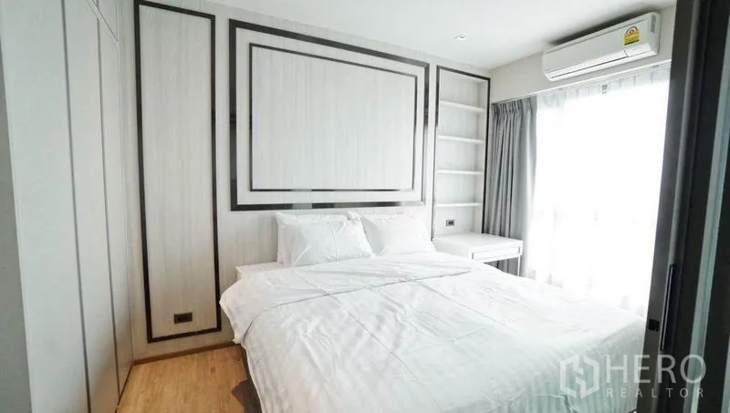 公寓 出售在Khlong Toei, Bangkok - 温馨卧室，配有大床、内置衣柜与搁架、空调及带薄纱窗帘的窗户。