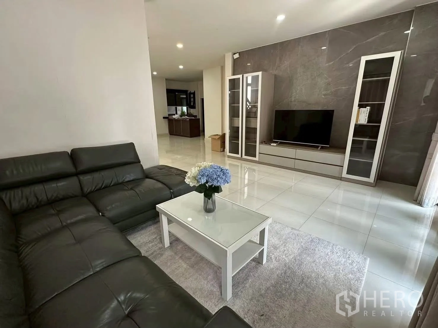 独栋房屋 for rent in Bang Phli, Samut Prakan - 客厅沙发对面为电视墙与玻璃展示柜。