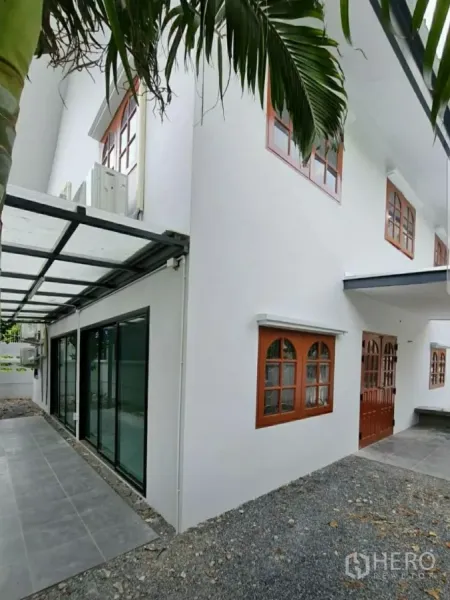 สำนักงานที่บ้าน ให้เช่าในLat Phrao, Bangkok - ด้านข้างบ้านมีทางเดินหลังคาโปร่ง ประตูกระจกบานเลื่อน และหน้าต่างกรอบไม้