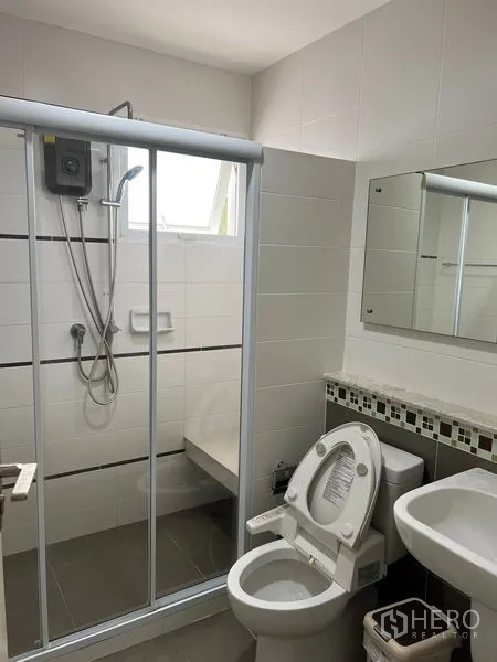 Detached House for rent in Bang Kapi, Bangkok - Modern bathroom with glass-enclosed shower, water heater, vanity mirror, and toilet.
