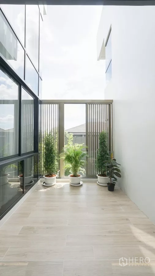 独立式住宅 出租或出售在Bang Kapi, Bangkok - 半室外阳台，摆放绿植与浅木纹地砖。