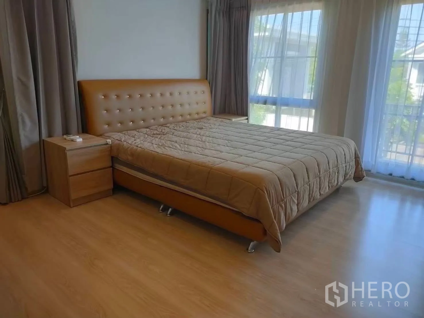 บ้านเดี่ยว for rent in Bang Phli, Samut Prakan - ห้องนอนมุมเตียงหัวบุหนังสีน้ำตาล พร้อมโต๊ะข้างและหน้าต่างบานใหญ่