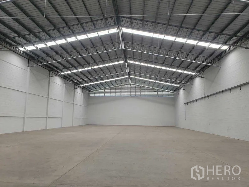 货栈 出租在Khlong Luang, Pathum Thani - 宽敞仓库内部，高钢结构屋顶带天窗，光滑混凝土地面。
