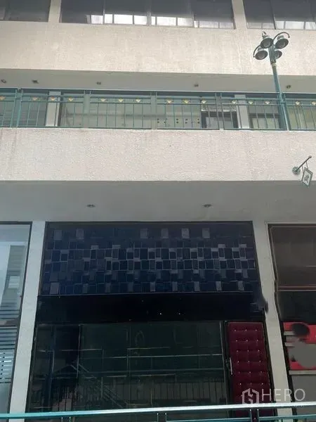 店屋 出租在Huai Khwang, Bangkok - 商业走廊内的商铺外立面，带阳台栏杆与宽大的玻璃门面。