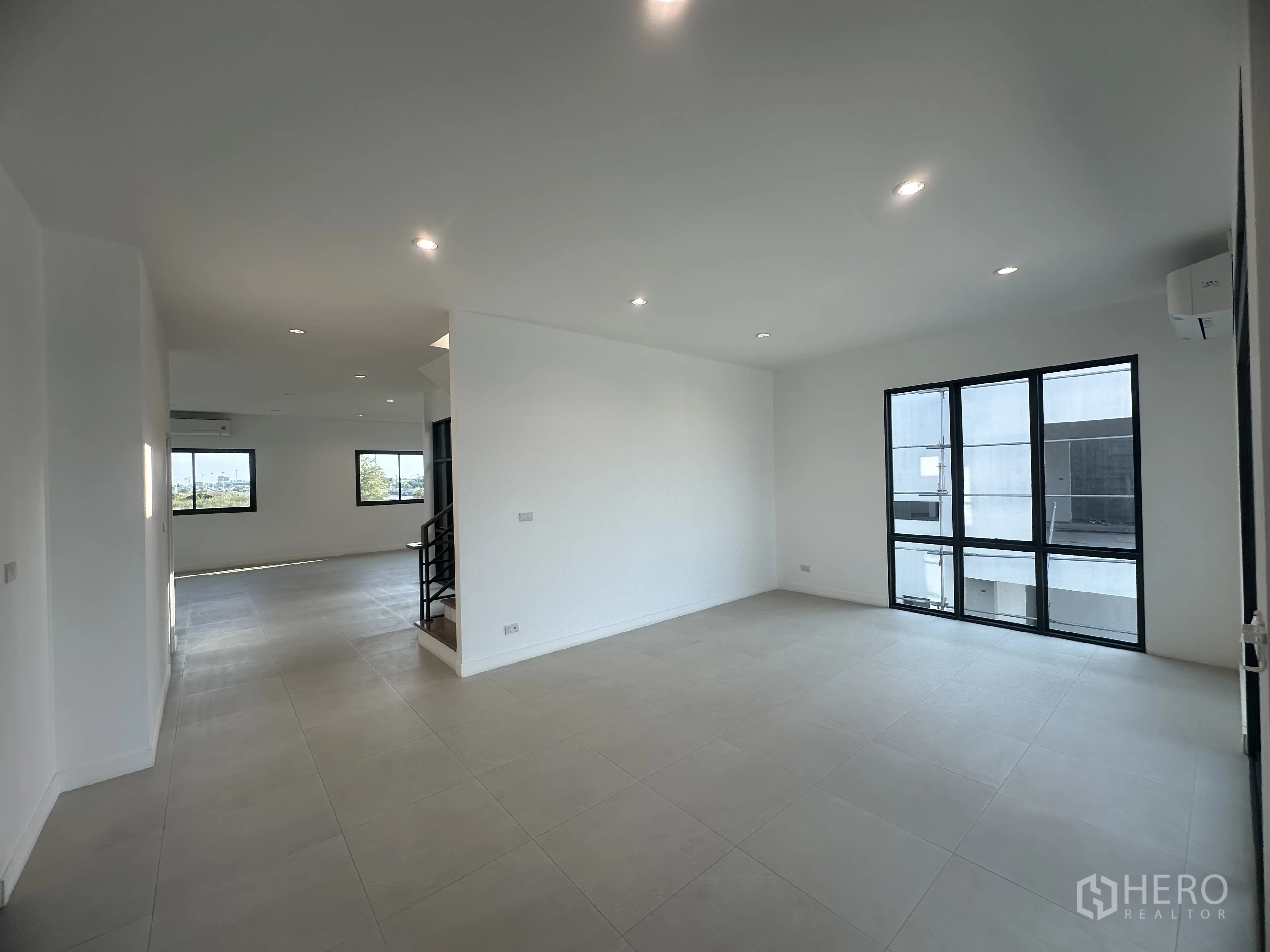 Home Office for sale in Khlong Luang, Pathum Thani - Spacious open-plan area with multiple windows and neutral floor tiles.