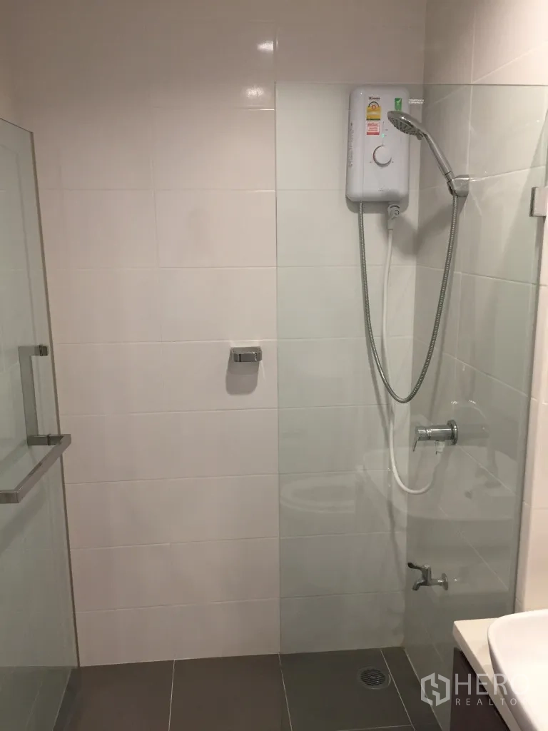 Townhouse for rent in Bang Kapi, Bangkok - Modern bathroom with glass shower enclosure, handheld shower and water heater.