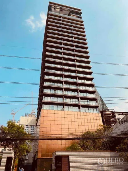 Condominium for sale in Watthana, Bangkok - Modern high-rise condominium tower in Thonglor, Watthana under a blue sky.