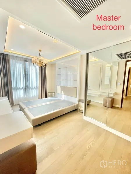 Condominium for sale in Huai Khwang, Bangkok - Master bedroom view with large windows, padded headboard and mirrored wardrobe.