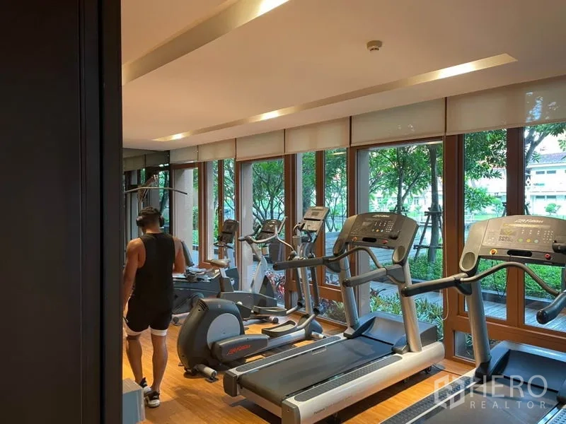 Condominium for sale in Watthana, Bangkok - Fully equipped fitness room with cardio machines overlooking the garden.
