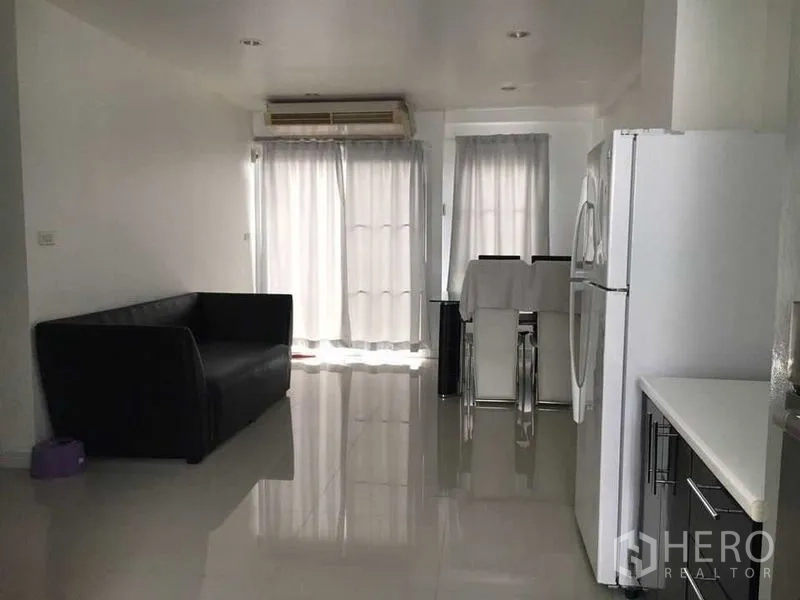 联排别墅 出售在Wang Thonglang, Bangkok - 明亮客餐厅，黑色沙发、冰箱与落地窗白色窗帘