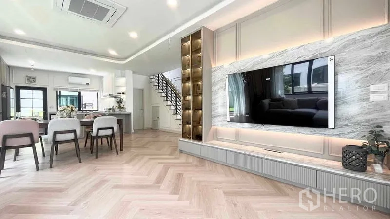 Detached House for rent in Bang Phli, Samut Prakan - Living and dining room with herringbone floor and marble feature wall TV unit