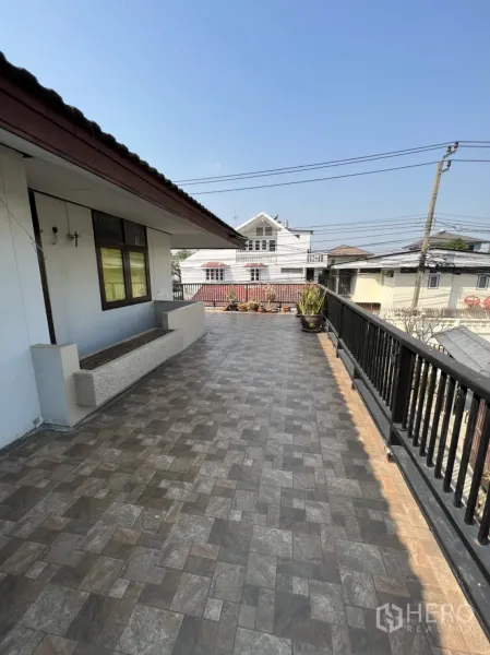 Home Office for rent in Watthana, Bangkok - Spacious tiled rooftop terrace with railing and neighborhood views.