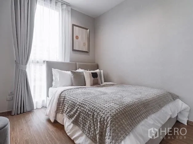 Condominium for rent in Watthana, Bangkok - Guest bedroom with window, gray bedding and minimal decor.