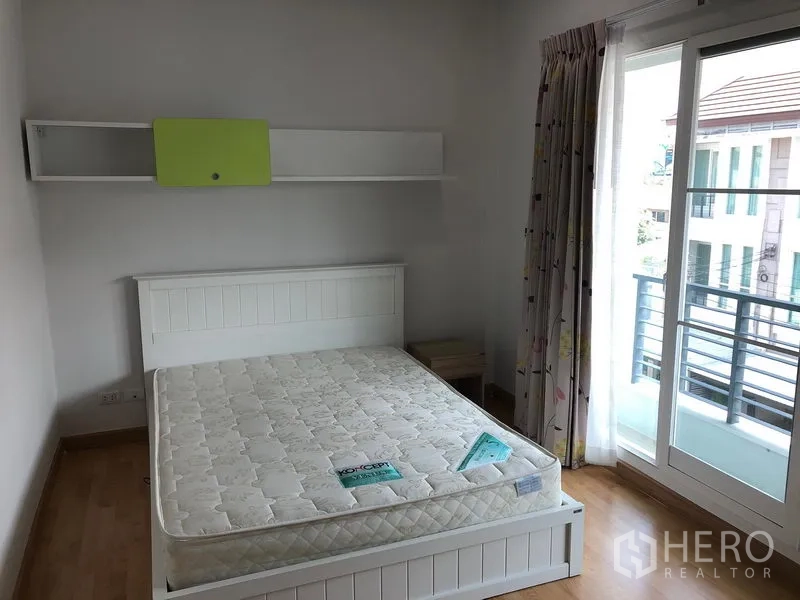 联排别墅 出租或出售在Wang Thonglang, Bangkok - 温馨卧室，白色床与推拉玻璃门，可通往小阳台。