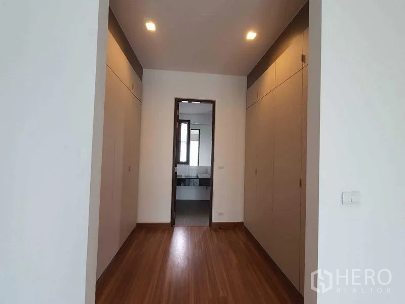 Detached House for rent or sale in Thanyaburi, Pathum Thani - Walk-in closet corridor with full-height wardrobes leading to the bathroom.