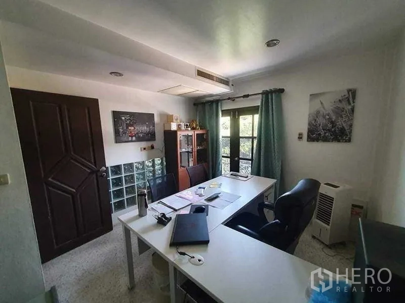 Townhouse for rent or sale in Bang Kho Laem, Bangkok - Home office with two desks, storage cabinets and doors to a small balcony.