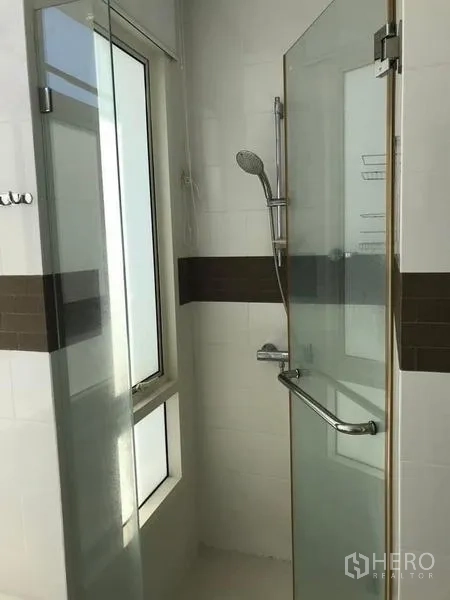 Condominium for rent or sale - Modern bathroom with glass shower enclosure and window in Bangkok condo.