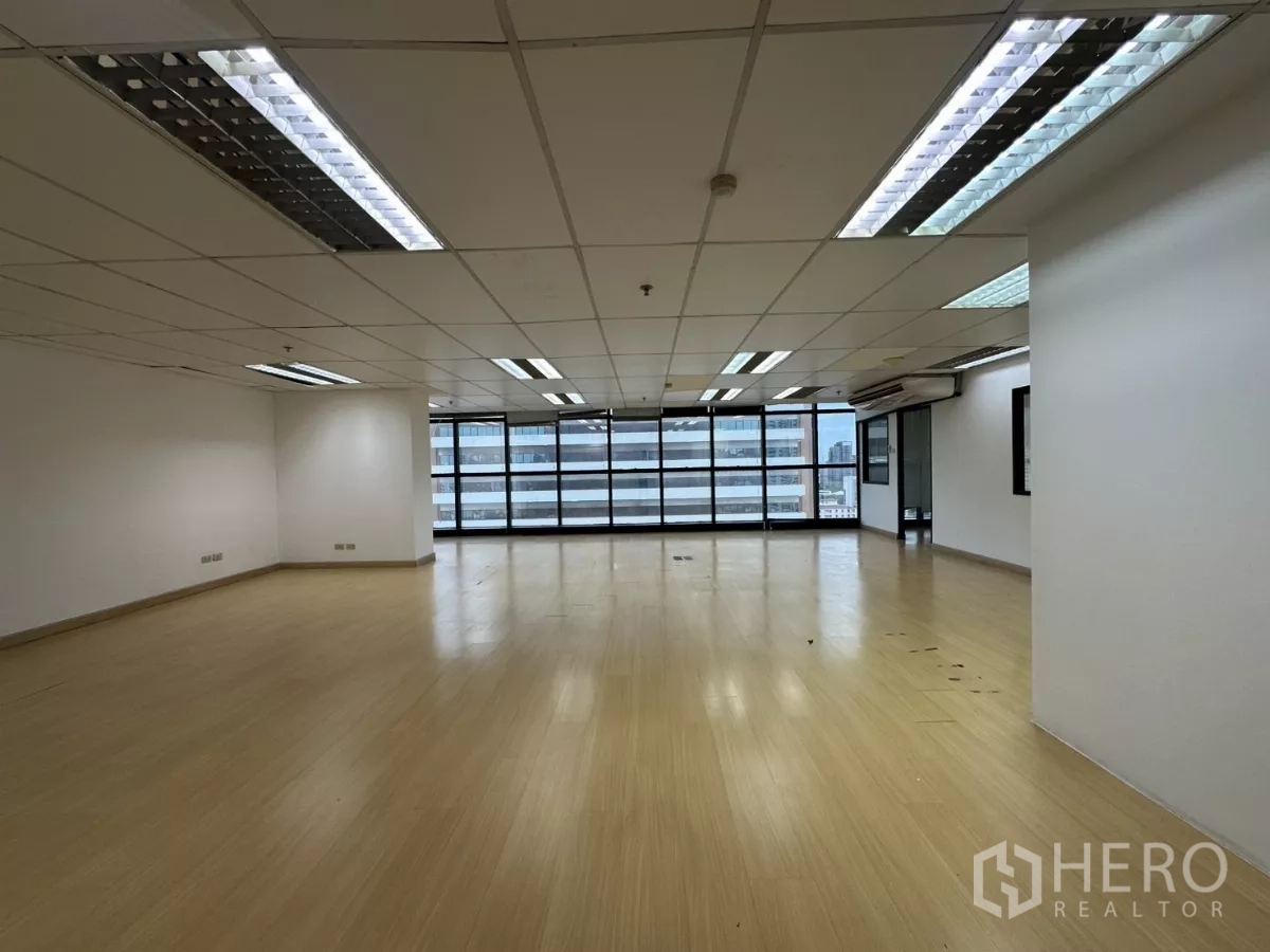Office Space for rent in Watthana, Bangkok - Wide open office area with grid ceiling lights and a full run of windows.