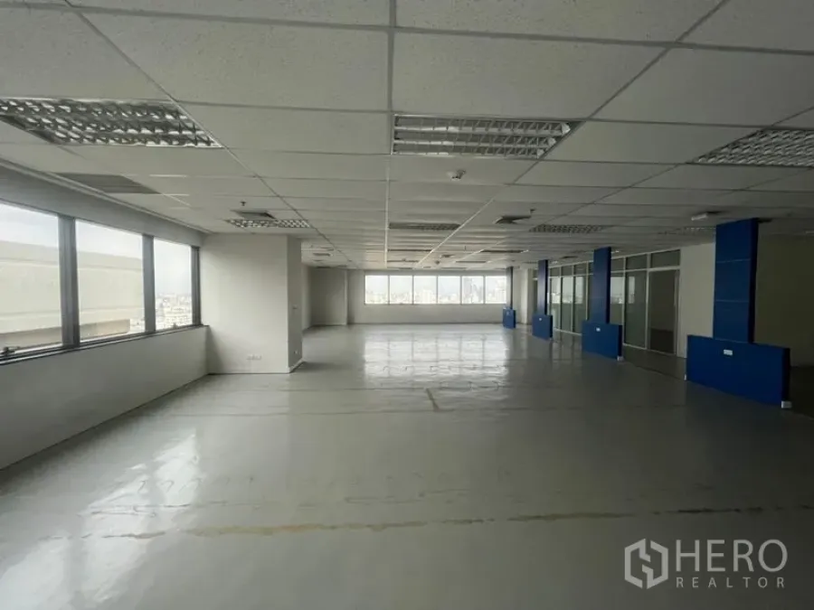 办公空间 出租 - 开放式办公楼层，网格吊顶灯与长排窗户，享城市景观。