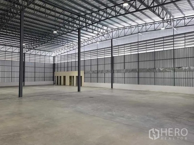 Warehouse for rent in Khlong Sam Wa, Bangkok - Expansive high-bay warehouse with steel columns, skylights, and smooth concrete flooring.