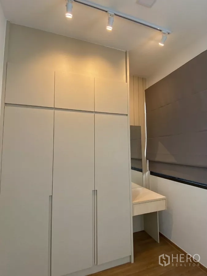 Townhouse for rent in Bang Phli, Samut Prakan - Detail of floor-to-ceiling wardrobe and vanity next to a window with blinds.