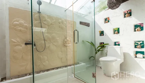 Detached House for sale in Hua Hin, Prachuap Khiri Khan - Bright bathroom with glass shower, skylight and floral carved feature wall.