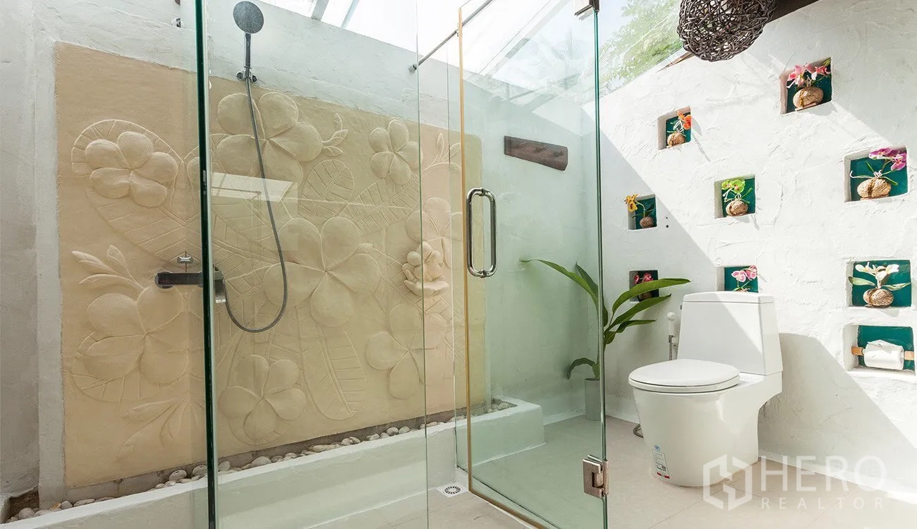 Detached House for sale in Hua Hin, Prachuap Khiri Khan - Bright bathroom with glass shower, skylight and floral carved feature wall.
