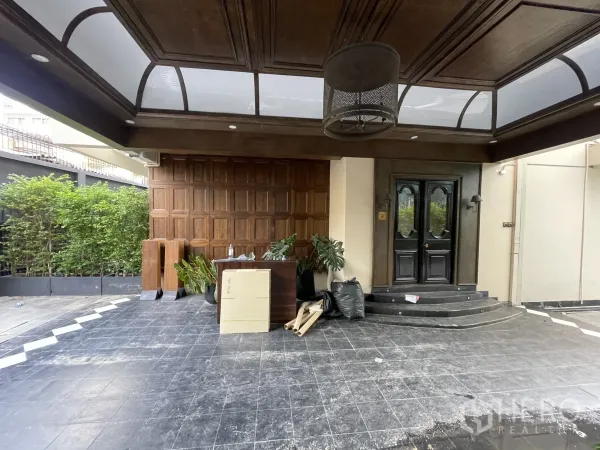 Detached House for rent - Front entry with paneled wood wall and skylight canopy over a tiled forecourt.